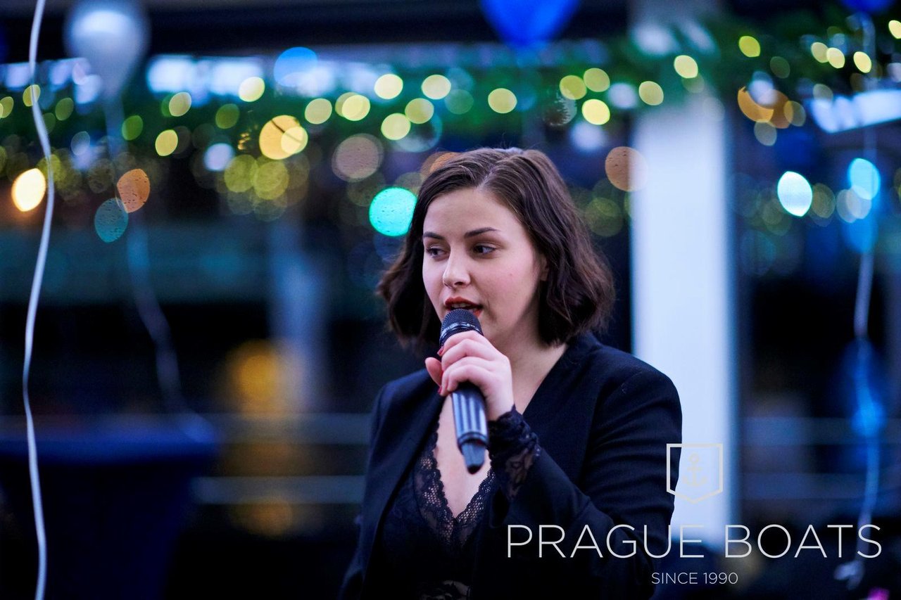 A woman singing on a boat decorated for Christmas