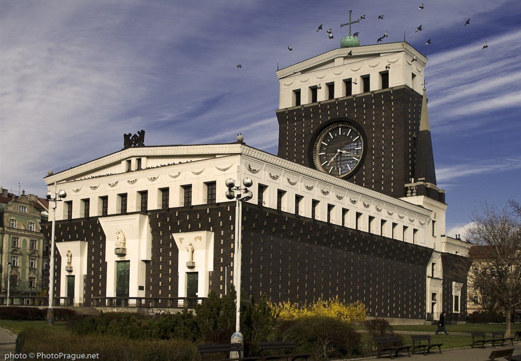 A large black church with a white roof, topped by a large black clock