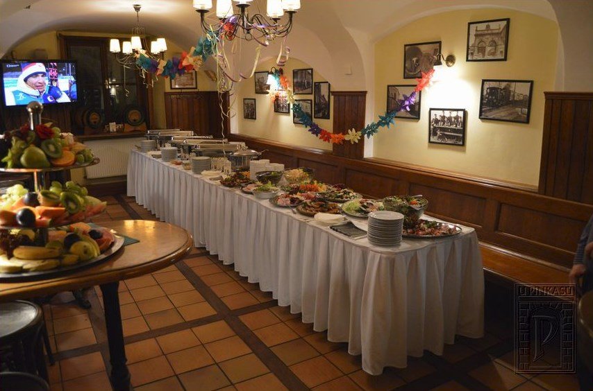 There is a large buffet on the table on the right and a large fruit platter on the left