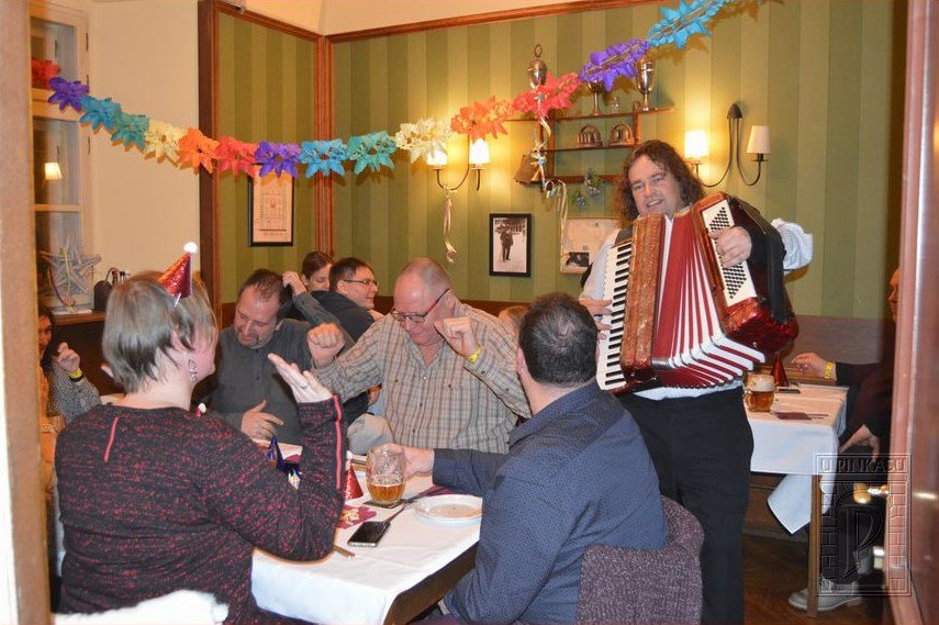 A man playing the accordion in a brasserie